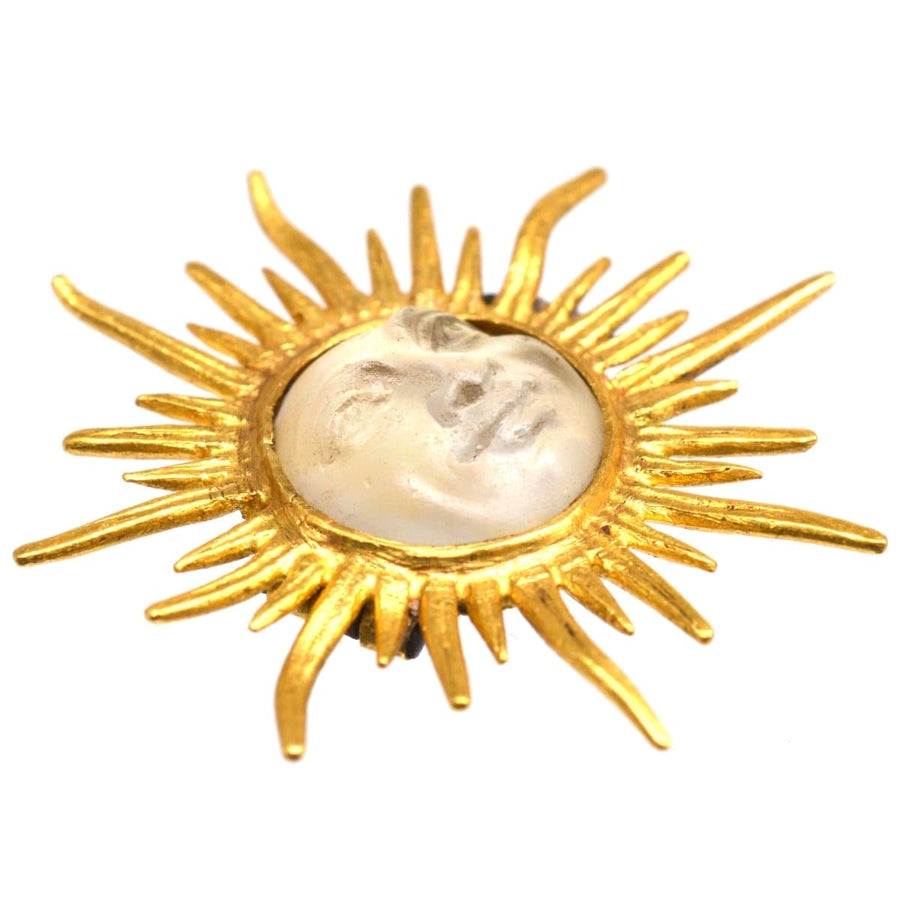 Elegant Edwardian sunburst brooch featuring a man in the moon design in opalescent glass, circa 1910s.