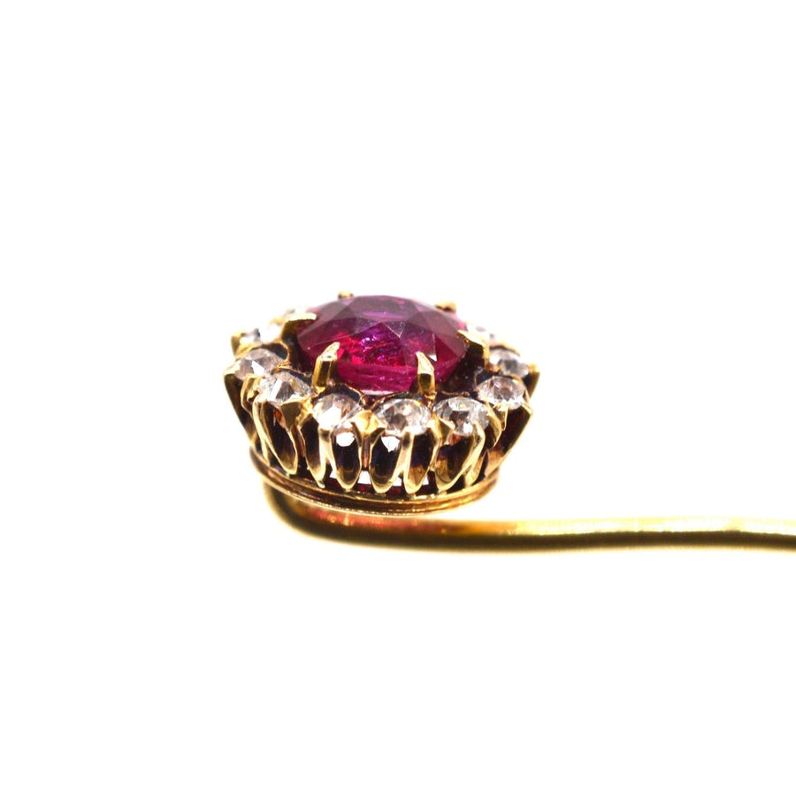 Close-up of Edwardian gold tie pin featuring a vibrant pigeon blood ruby surrounded by diamond clusters.