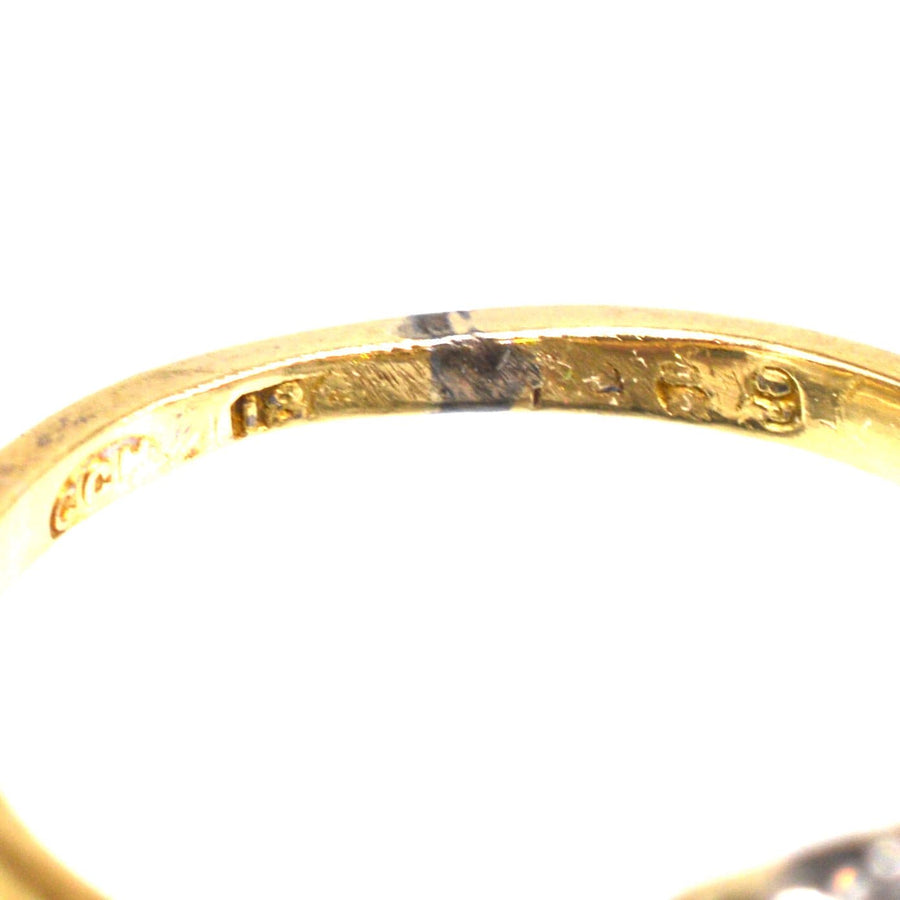 Close-up of an Edwardian 18ct gold and platinum diamond cluster ring's inner band with engraving.