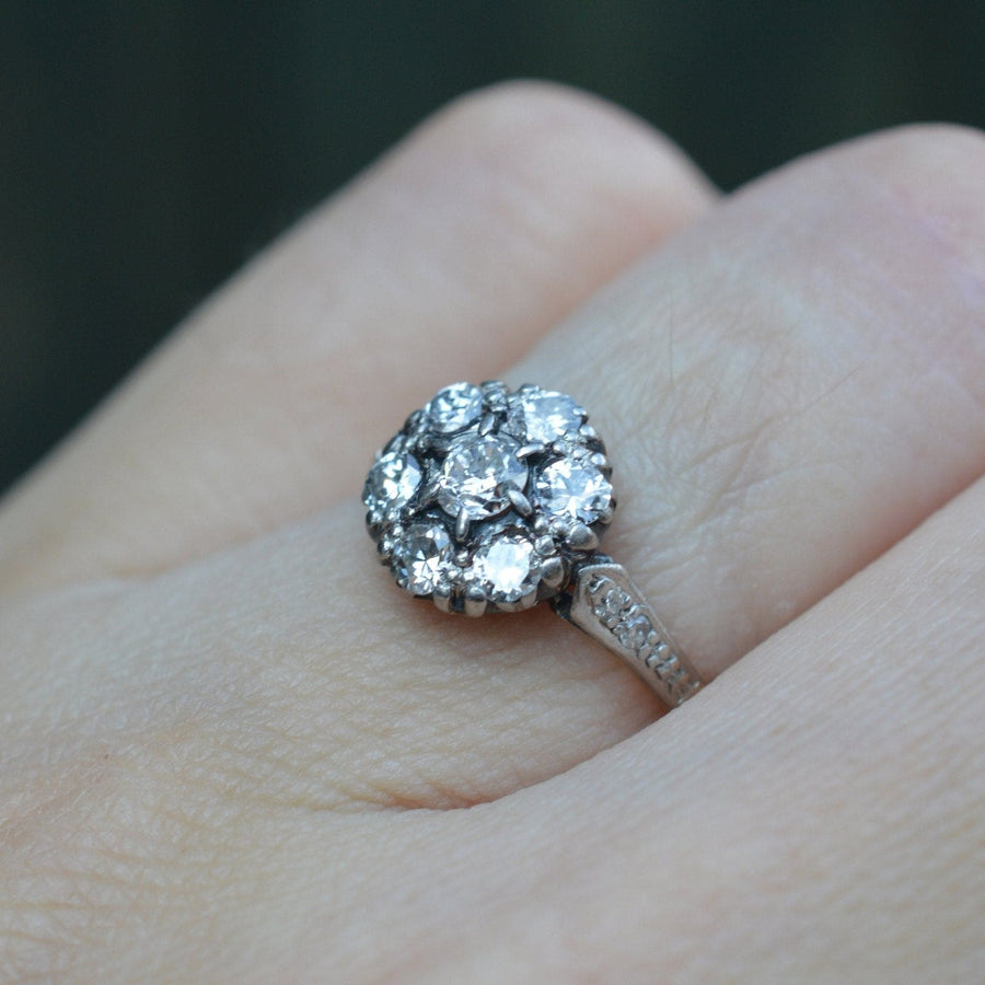 Edwardian 18ct gold and platinum diamond cluster ring on hand, showcasing approx. 0.70 carats of brilliant diamonds.