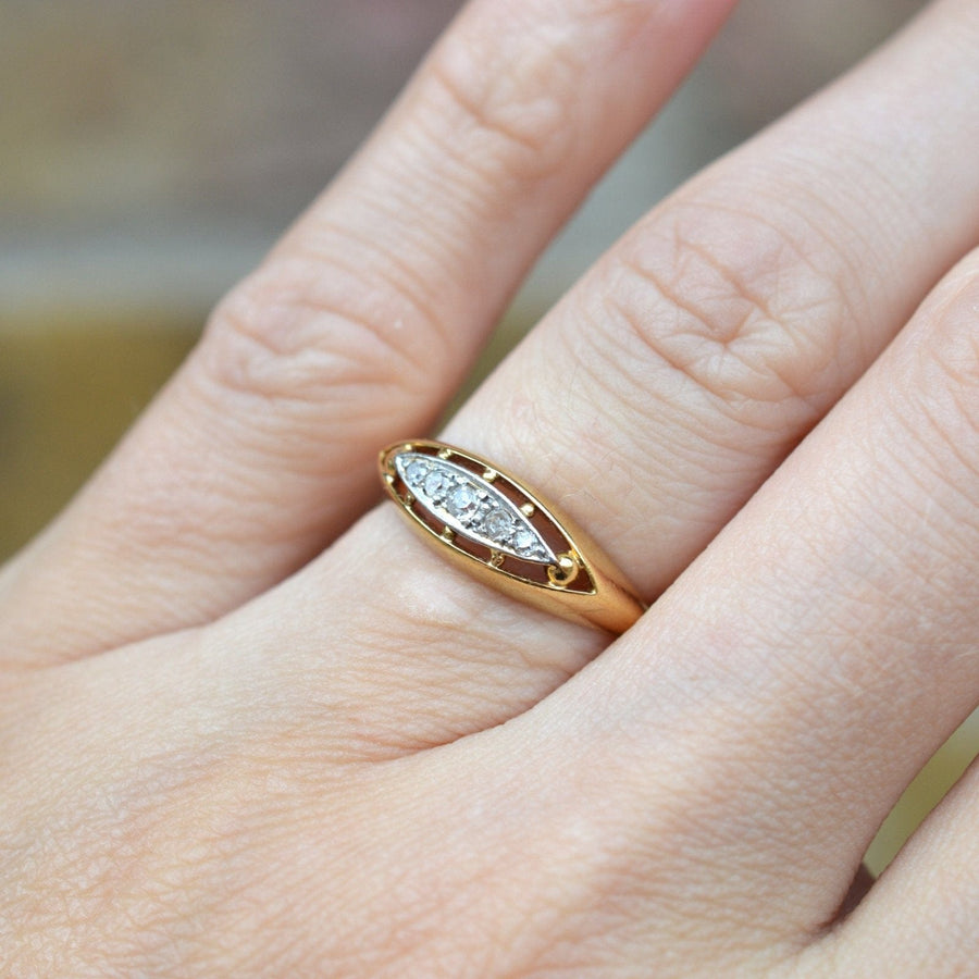 Edwardian 18ct gold and platinum five stone diamond ring in boat shape worn on a finger.