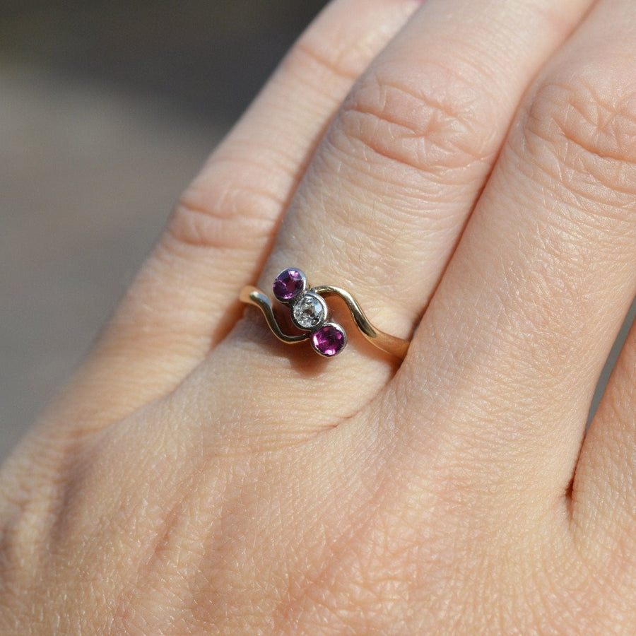 Edwardian 18ct gold and platinum crossover ring with rubies and diamond on a hand.