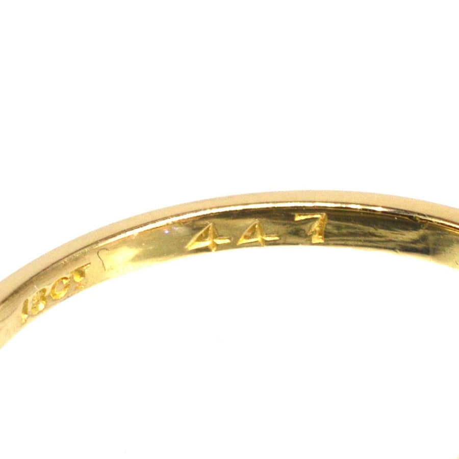 Close-up of the inside of an Edwardian 18ct gold and platinum ring showing hallmark details.
