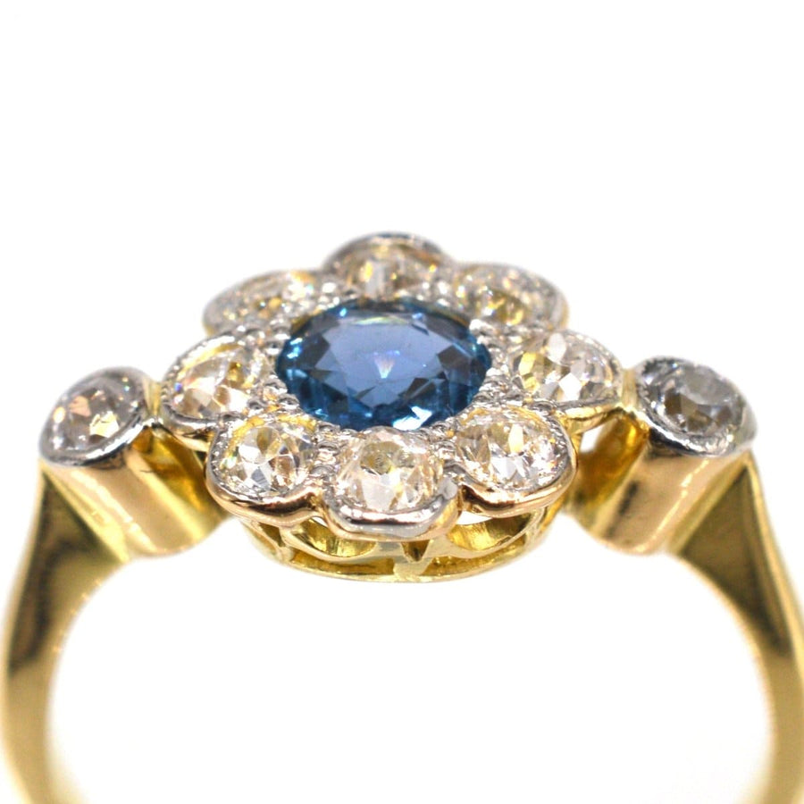 Edwardian 18ct gold and platinum sapphire diamond cluster ring, featuring a blue sapphire at the center with diamond accents.