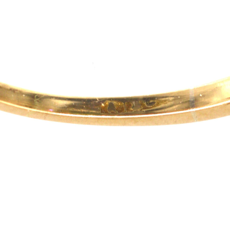 Close-up view of the inside band of an Edwardian gold ring, showcasing its craftsmanship and hallmark details.