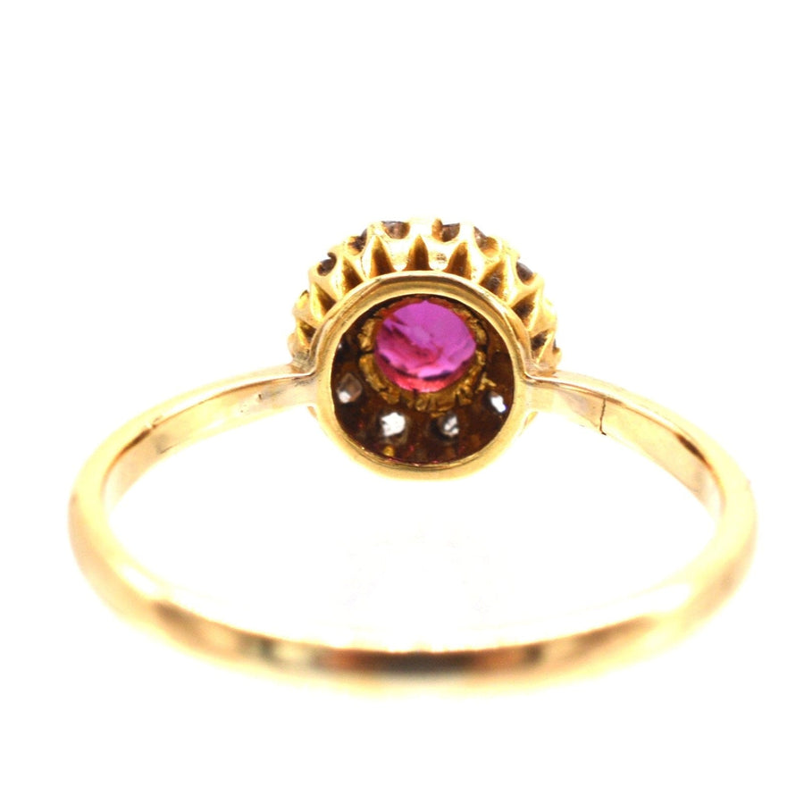 Edwardian 18ct gold ruby and diamond cluster ring, featuring a central ruby and ten sparkling diamonds.