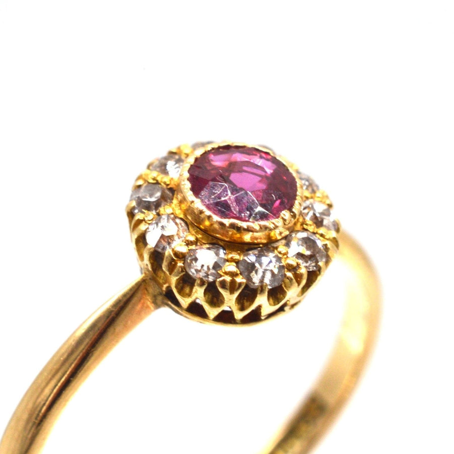 Edwardian 18ct gold cluster ring featuring a central ruby surrounded by ten sparkling diamonds.