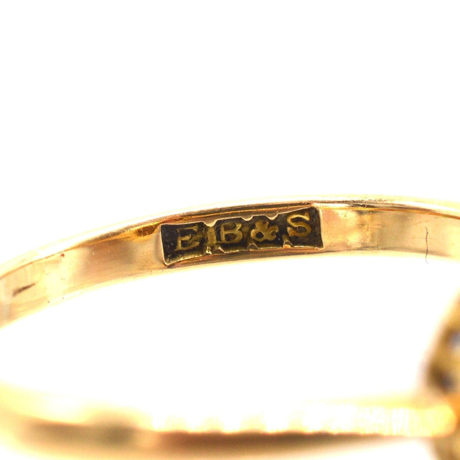 Close-up of the hallmark on an Edwardian 18ct gold ruby and diamond cluster ring, featuring E.B.&S. stamp.