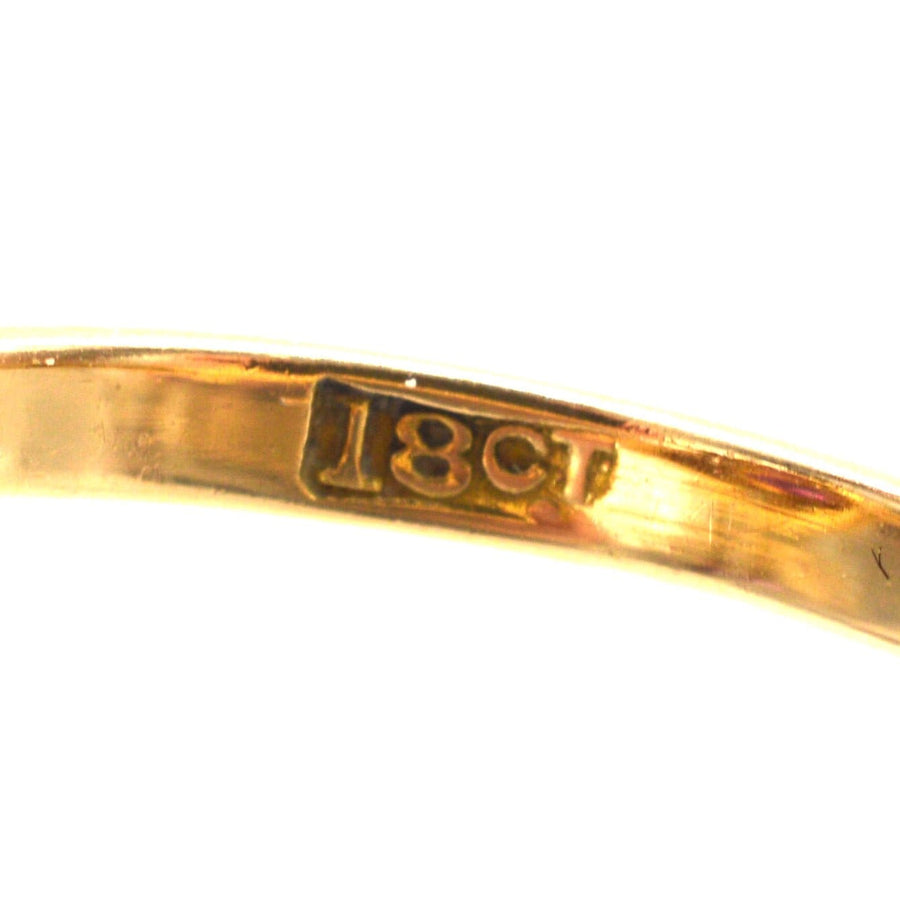 Close-up of the hallmark on an 18ct gold ring, indicating purity and quality of the material.