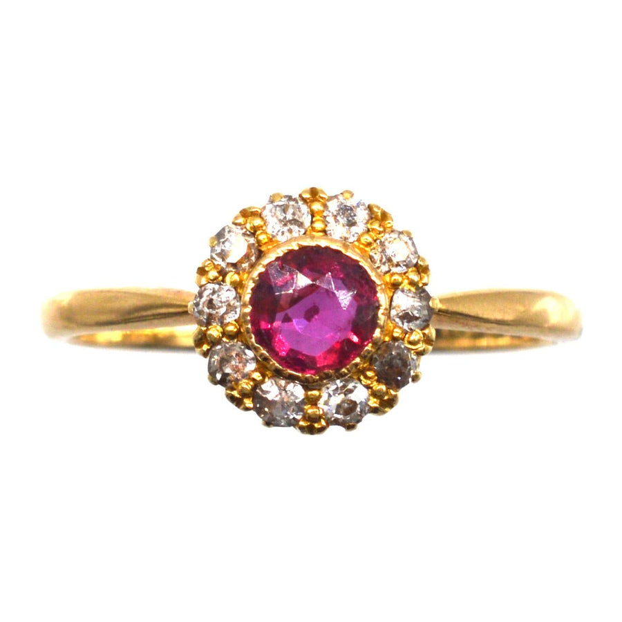 Edwardian 18ct gold ruby and diamond cluster ring, featuring a vibrant ruby surrounded by sparkling diamonds.