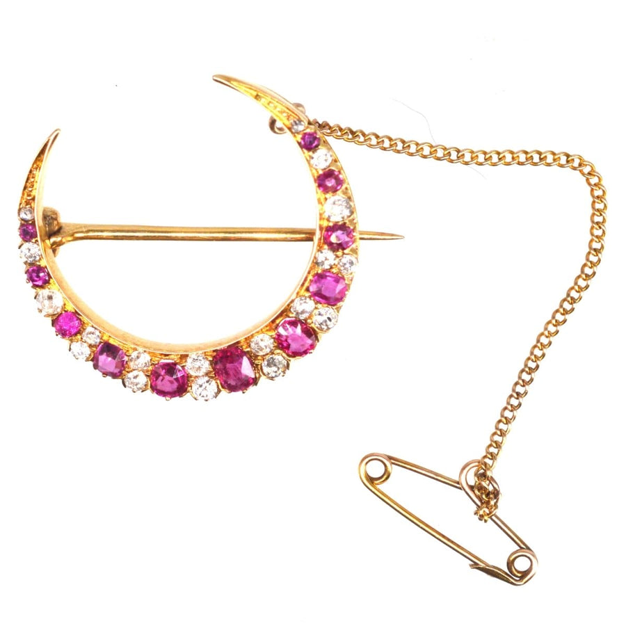 Edwardian 18ct gold crescent moon brooch with ruby and diamond detailing, featuring a safety chain.