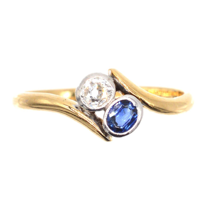 Edwardian 18ct gold crossover ring featuring diamond and sapphire, perfect romantic engagement piece.