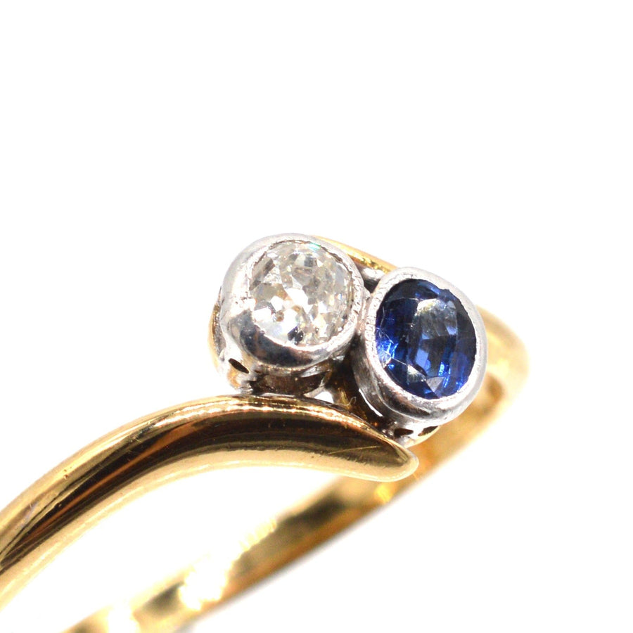 Edwardian 18ct gold crossover ring with diamond and sapphire stones, symbolizing love and connection.
