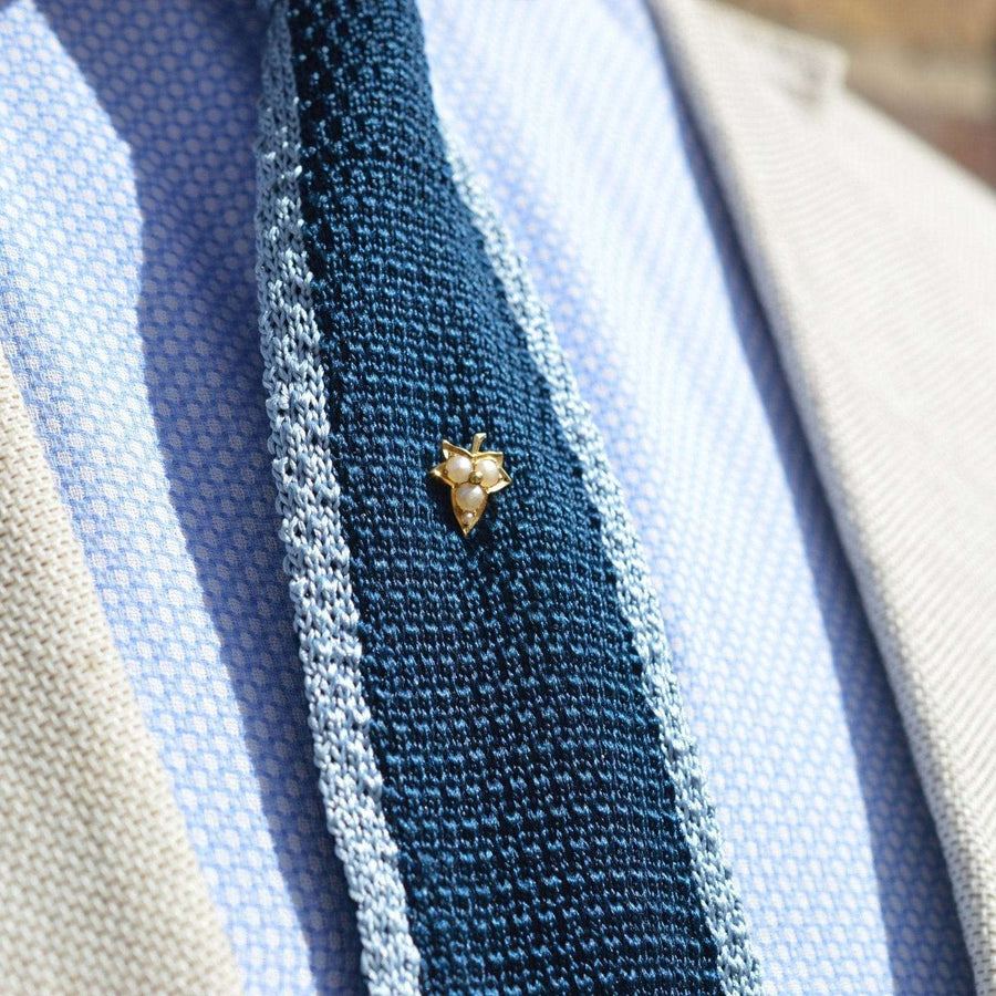 Edwardian 18ct gold ivy leaf tie pin with split pearls on a textured blue tie, perfect for groom gifts.