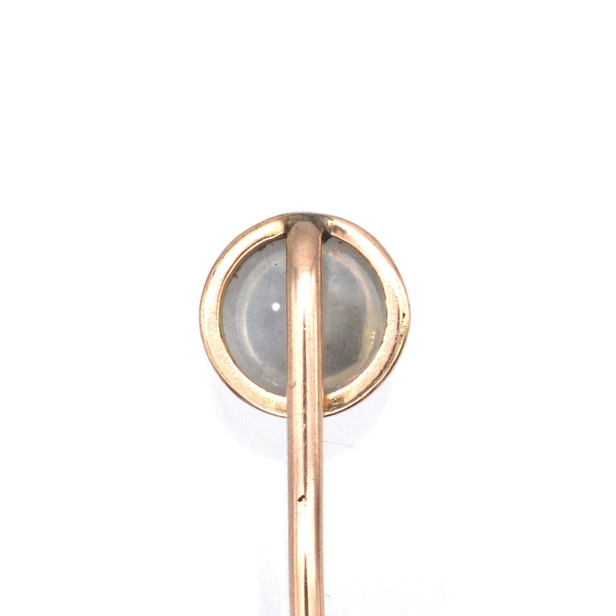 Close-up of an Edwardian 18ct gold tie pin featuring a luminous moonstone, highlighting its unique bluey grey glow.