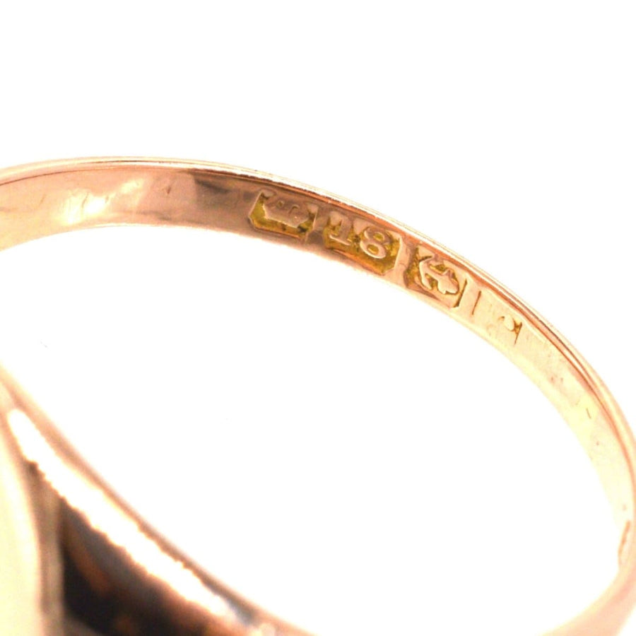 Close-up of the inside engraving of an Edwardian 18ct rose gold signet ring, showcasing its hallmarks.
