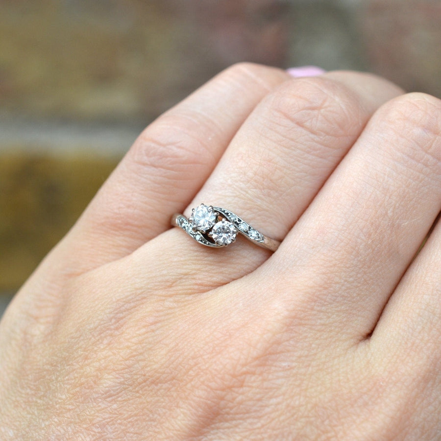 Edwardian 18ct white gold diamond 'Toi et Moi' crossover ring displayed on a hand.