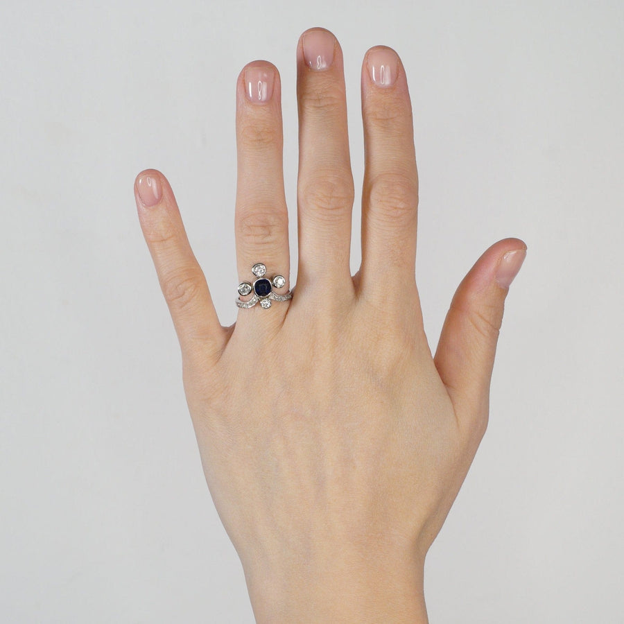 Edwardian 18ct white gold tiara ring featuring a sapphire and diamonds displayed on a hand.