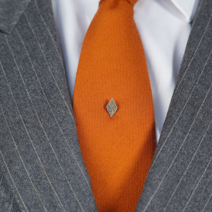 Elegant Edwardian 9ct gold engraved tie pin on an orange tie, showcasing a masculine yet delicate design.