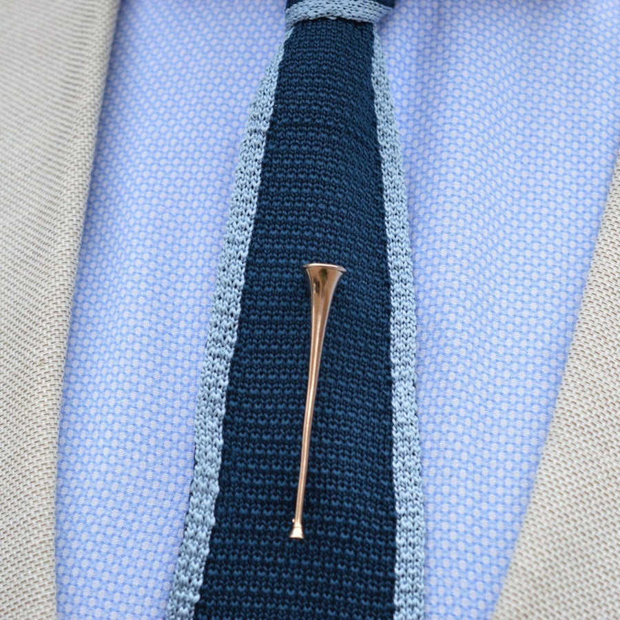 Edwardian 9ct gold hunting horn brooch displayed on a tie, adding a quirky touch to the outfit.