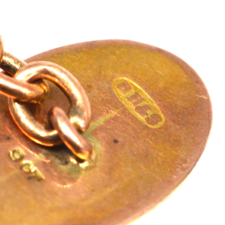 Close-up of Edwardian 9ct gold cufflink back showing maker's mark and metal content.