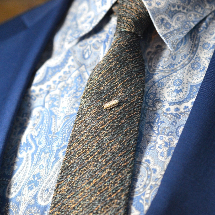 Edwardian Dutch platinum and gold tie pin with pearls, elegantly styled on a textured tie and shirt.
