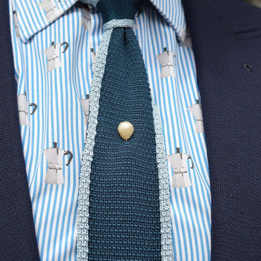 Edwardian large natural baroque pearl tie pin on a textured tie with a patterned shirt.