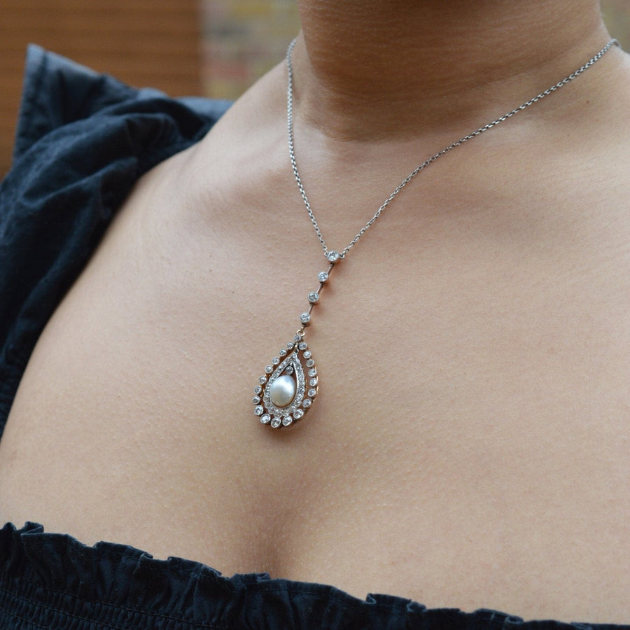 Edwardian platinum and gold diamond pendant featuring a natural saltwater pearl on a delicate chain.