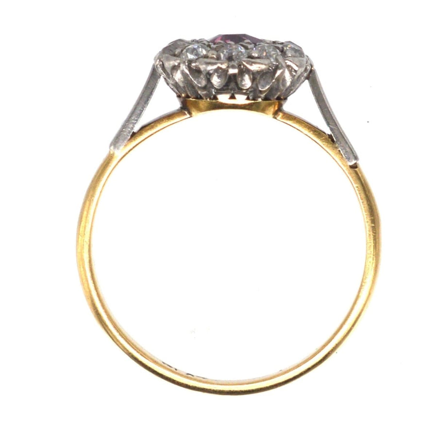 Edwardian platinum and 18ct gold ruby and diamond cluster ring, featuring a natural ruby encircled by diamonds.