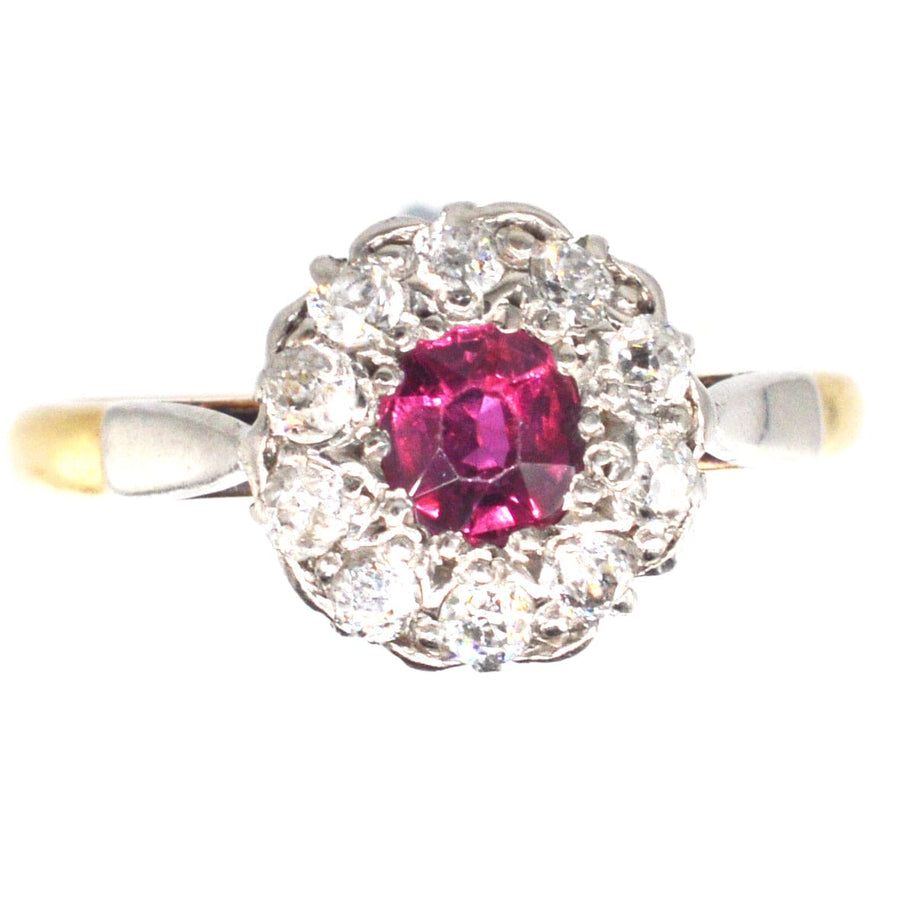 Edwardian platinum and gold ruby diamond cluster ring, featuring a central ruby surrounded by sparkling diamonds.