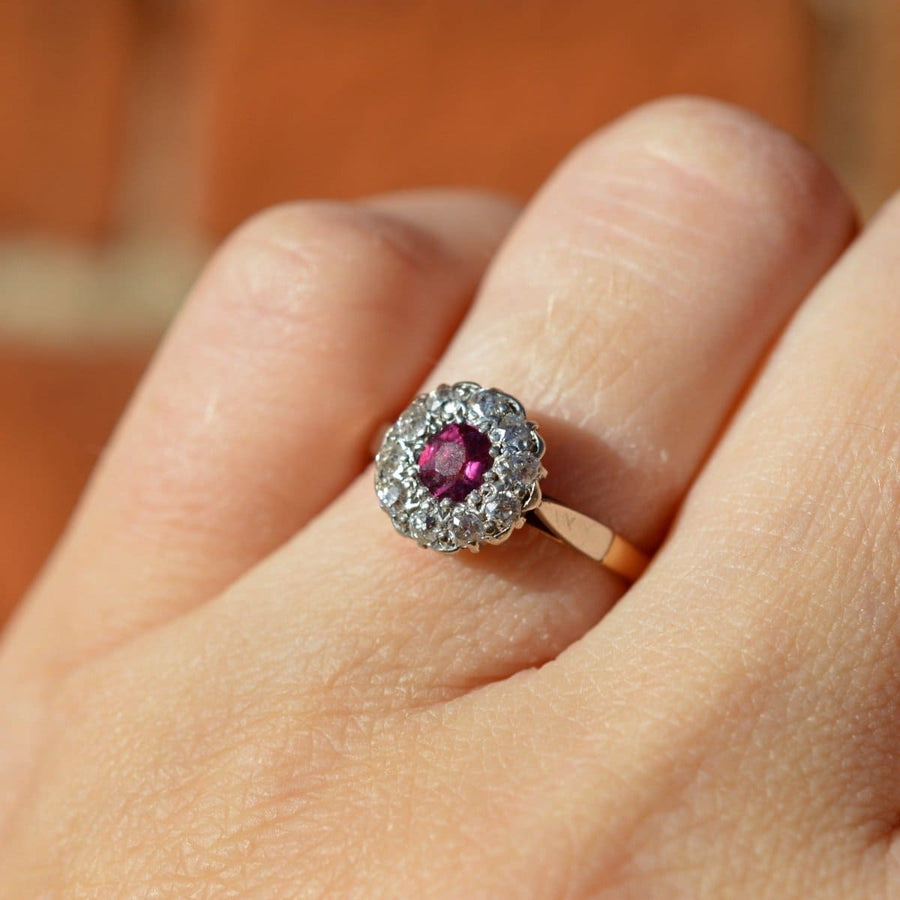 Edwardian platinum and gold ruby diamond cluster ring on hand, a timeless engagement ring for July birthdays.
