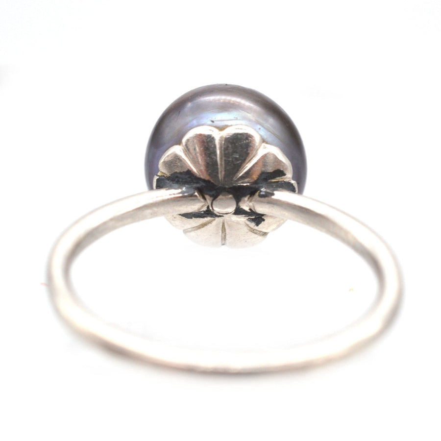 Edwardian platinum ring featuring a natural black saltwater pearl, showcasing an elegant floral design.