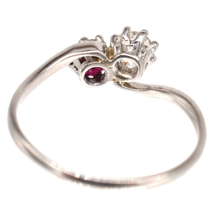 Edwardian platinum crossover ring featuring a vibrant ruby and old mine cut diamond, symbolizing love.
