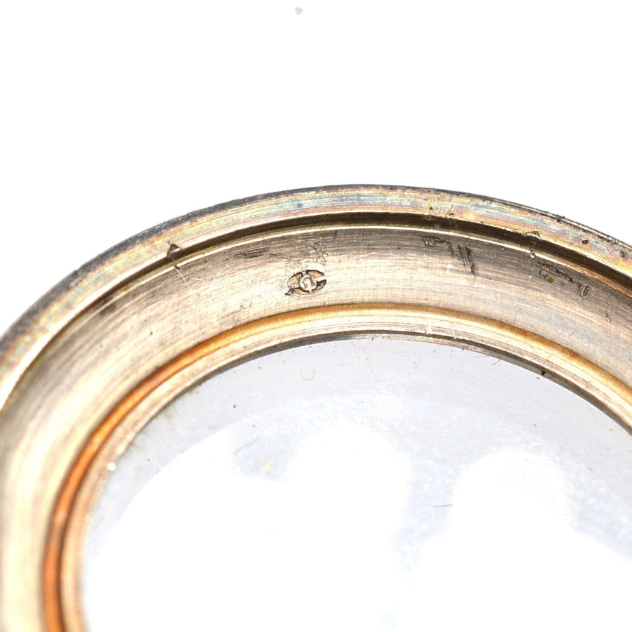 Close-up of the inner bezel of an Edwardian silver pocket watch, highlighting the intricate details and craftsmanship.