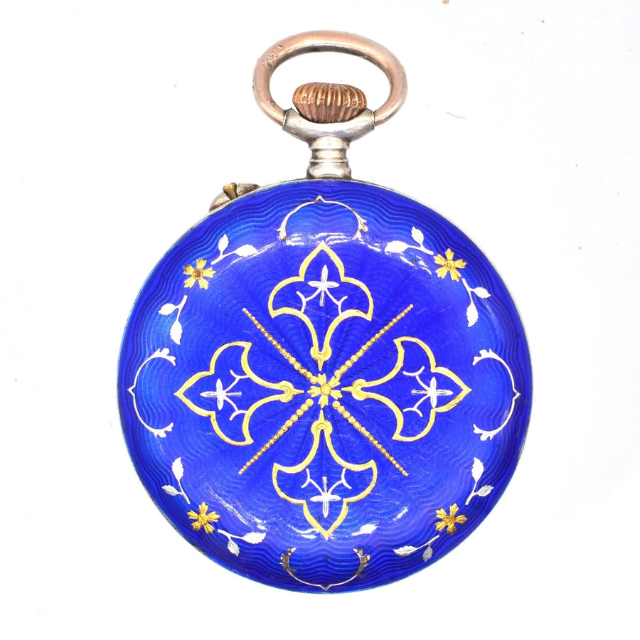 Edwardian silver pocket watch featuring royal blue guilloché enamel and intricate gold floral designs.