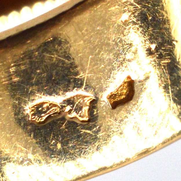 Close-up of gold hallmarking on a vintage ring, showcasing authenticity and craftsmanship details.