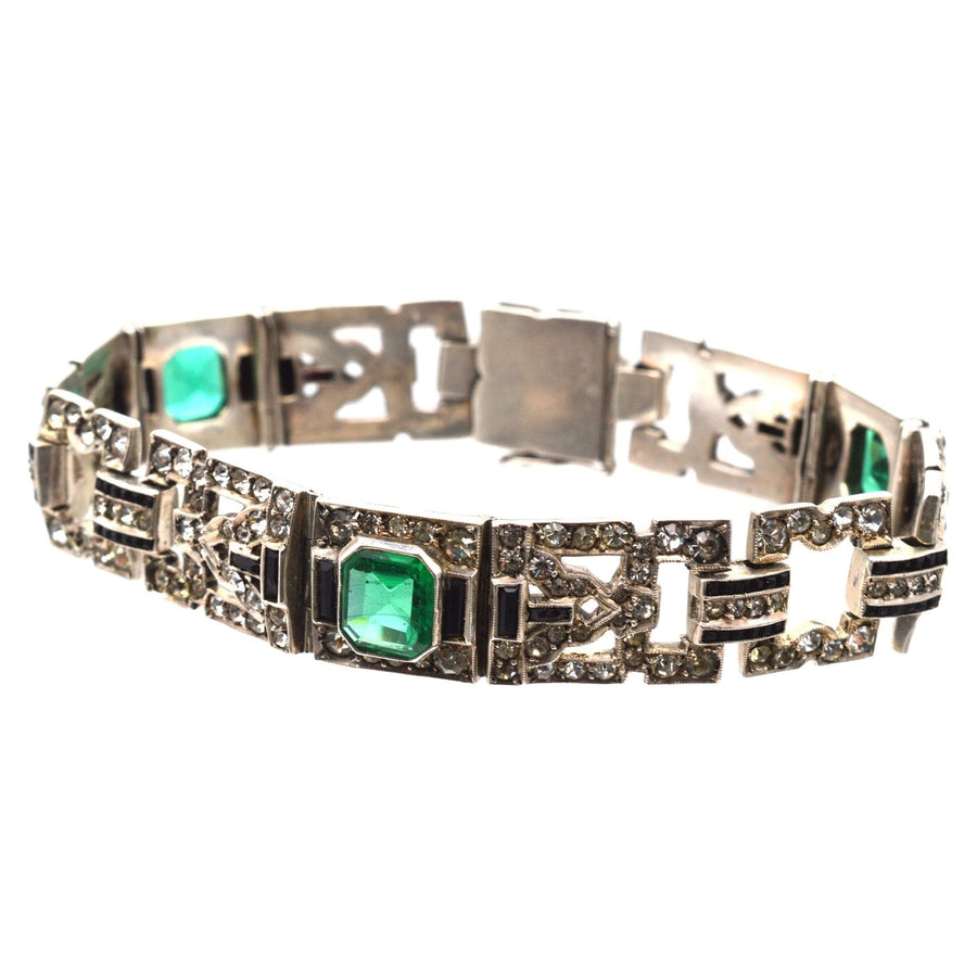 French Art Deco bracelet featuring emerald green and diamond paste stones in intricate design.