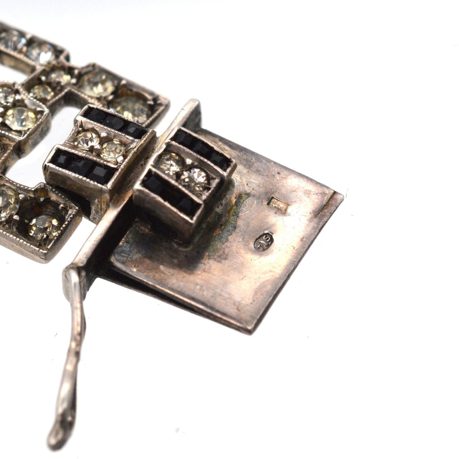 Close-up of the clasp on a French Art Deco emerald and diamond bracelet showcasing intricate silverwork and detail.