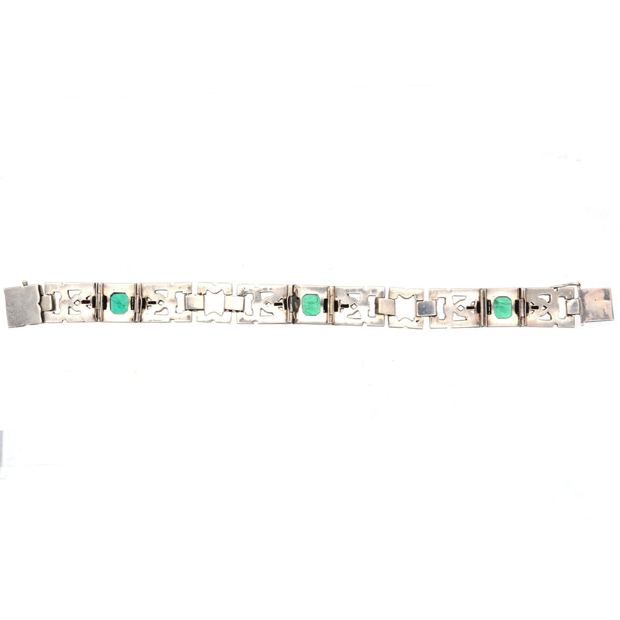 French Art Deco bracelet featuring emerald green, white diamond, and onyx paste in an elegant design.
