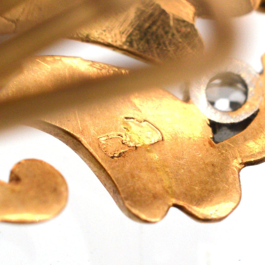 Close-up of the intricate 18ct gold detailing on vintage Belle Époque earrings with a hallmark.