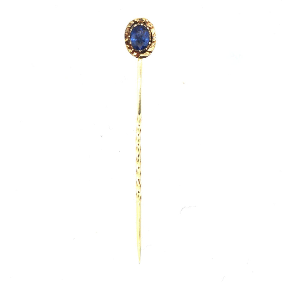 Georgian 15ct gold tie pin featuring a natural blue sapphire and intricate repoussé work, circa 1800-1820.