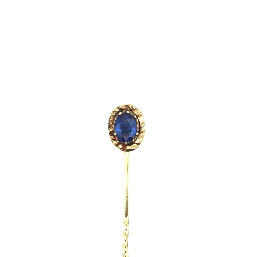 Georgian 15ct gold tie pin featuring a natural blue sapphire and intricate repoussé work, circa 1800-1820s.