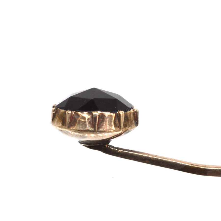 Close-up of a Georgian 9ct gold tie pin featuring a rose cut black Vauxhall Glass gem from the 1830s.