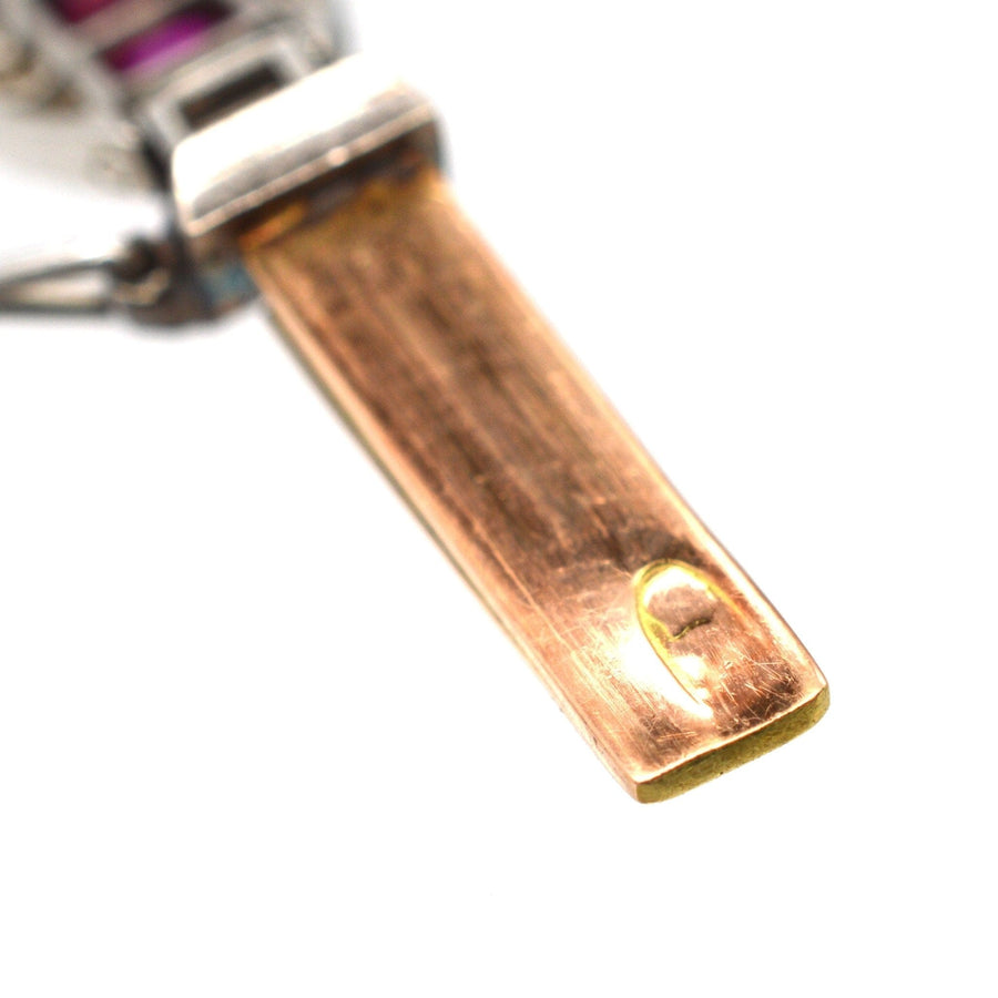 Close-up of the hallmarked gold and platinum bracelet showing the hallmark and gold finish.