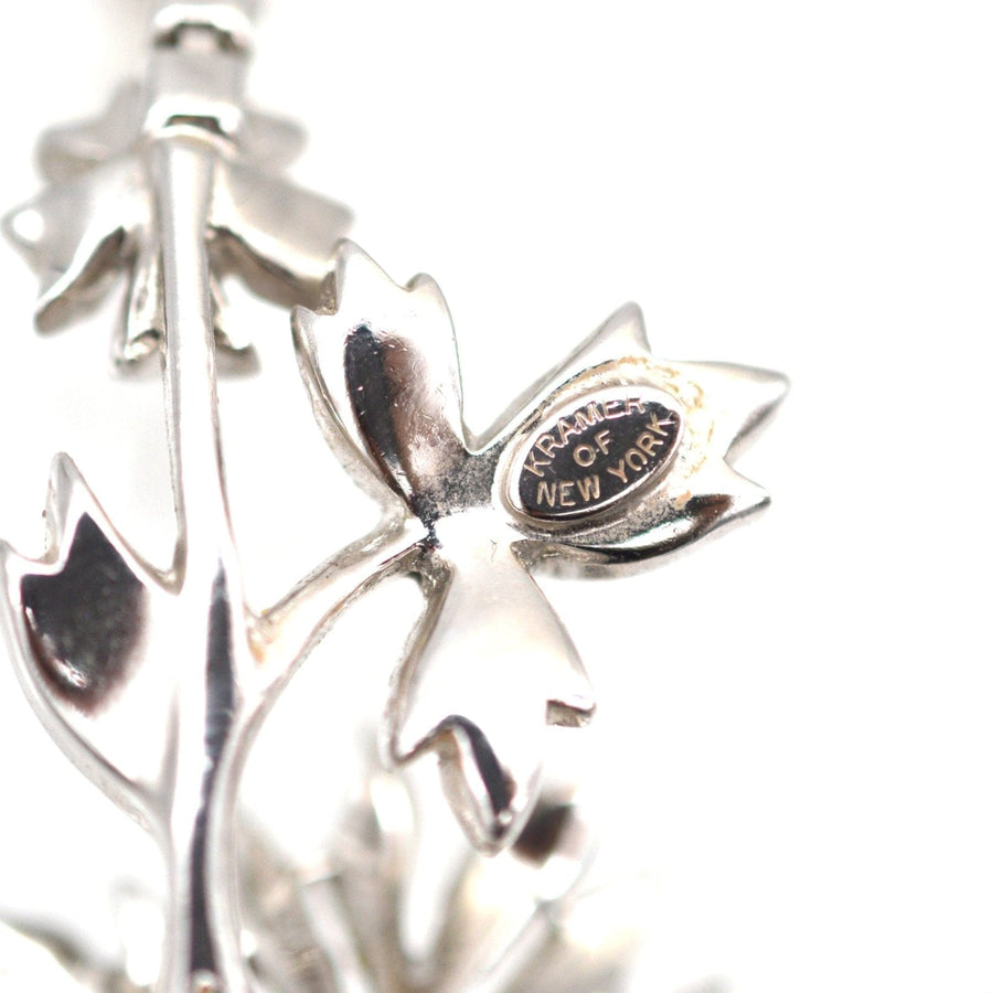 Close-up of vintage Kramer of New York necklace detail featuring intricate leaf design with logo.