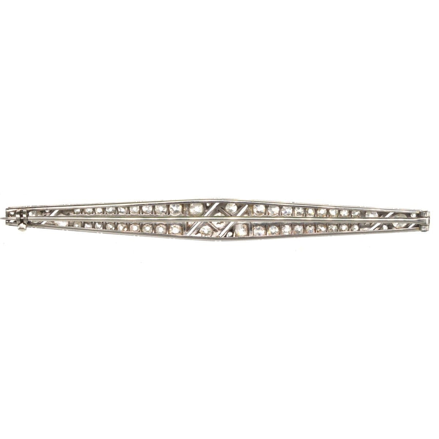 Large Art Deco platinum diamond bar brooch with intricate setting and geometric design, resembling a vintage propeller.