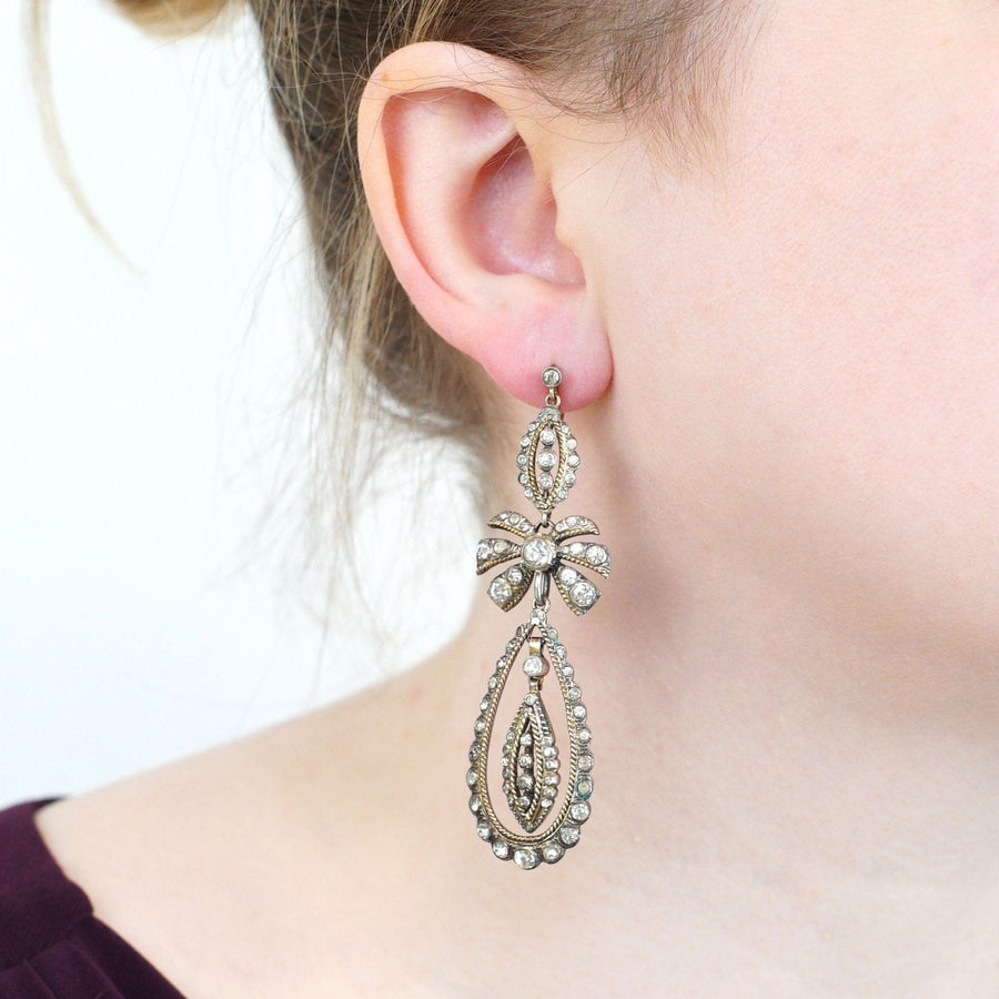 Large Art Deco silver and 9ct gold bow pendant earrings in vintage style worn by a model.