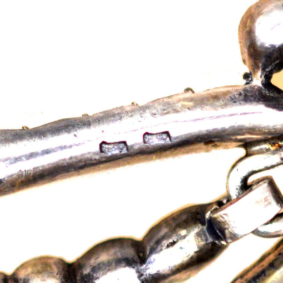 Close-up detail of silver craftsmanship on 19th century Portuguese style earrings, showcasing elegant articulation.