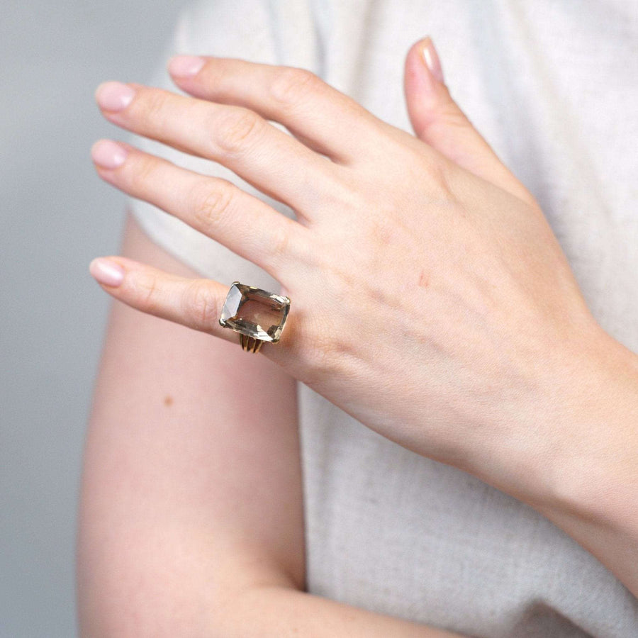 Large mid-century 9ct gold smoky quartz cocktail ring seen on a hand, featuring an openwork shank design.