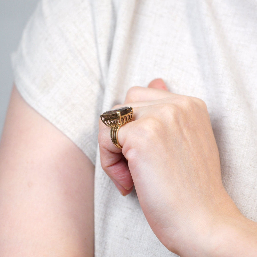 Large Mid Century 9ct gold smoky quartz cocktail ring on a hand, featuring an openwork shank.
